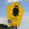 Biosphärenreservat-Schild mit Anti-Nazi-Aufkleber Biosphärenreservat-Schild (gelb mit schwarzer Eule), auf dem ein Anti-Nazi-Aufkleber (Hakenkreuz in die Abfalltonne) klebt