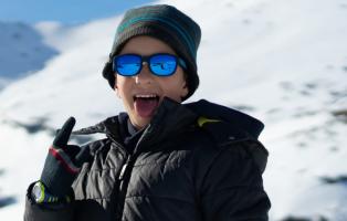 Lachendes Kind auf einem verschneitem Berg