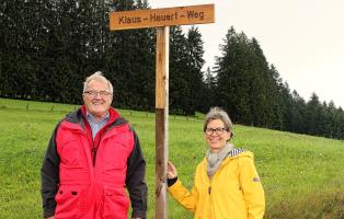 Klaus Hauert, jahrzehntelanger Motor der Hochtouristen Kandern, und Vorsitzende Lissi Geling bei der Enthüllung des Straßenschilds „Klaus Hauert-Weg“ in Strick, einem Ortsteil von Rickenbach.